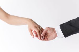 Hands exchanging a wedding ring in an intimate ceremony moment.