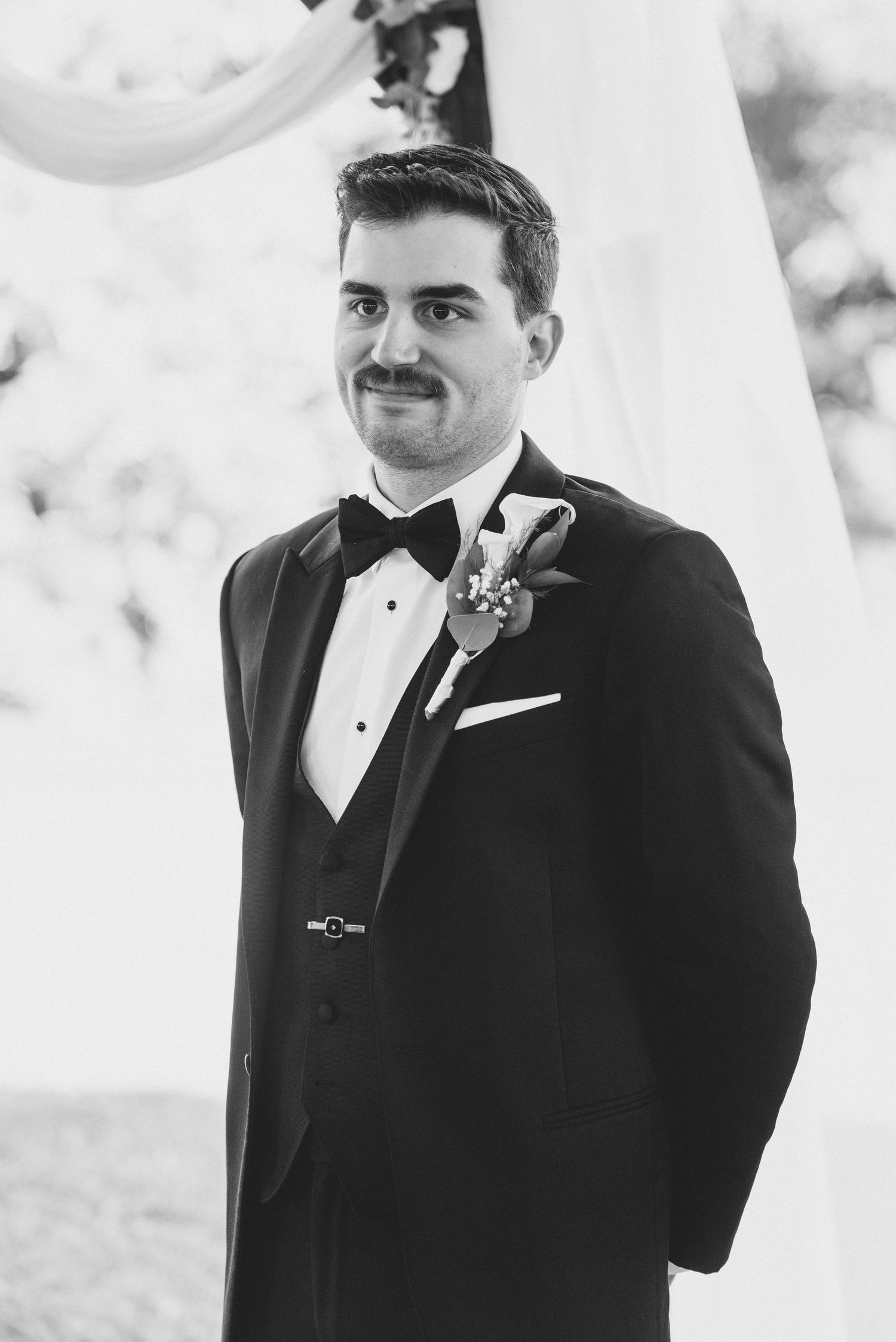 Four black and white photos show groom's emotional reactions during wedding ceremony.