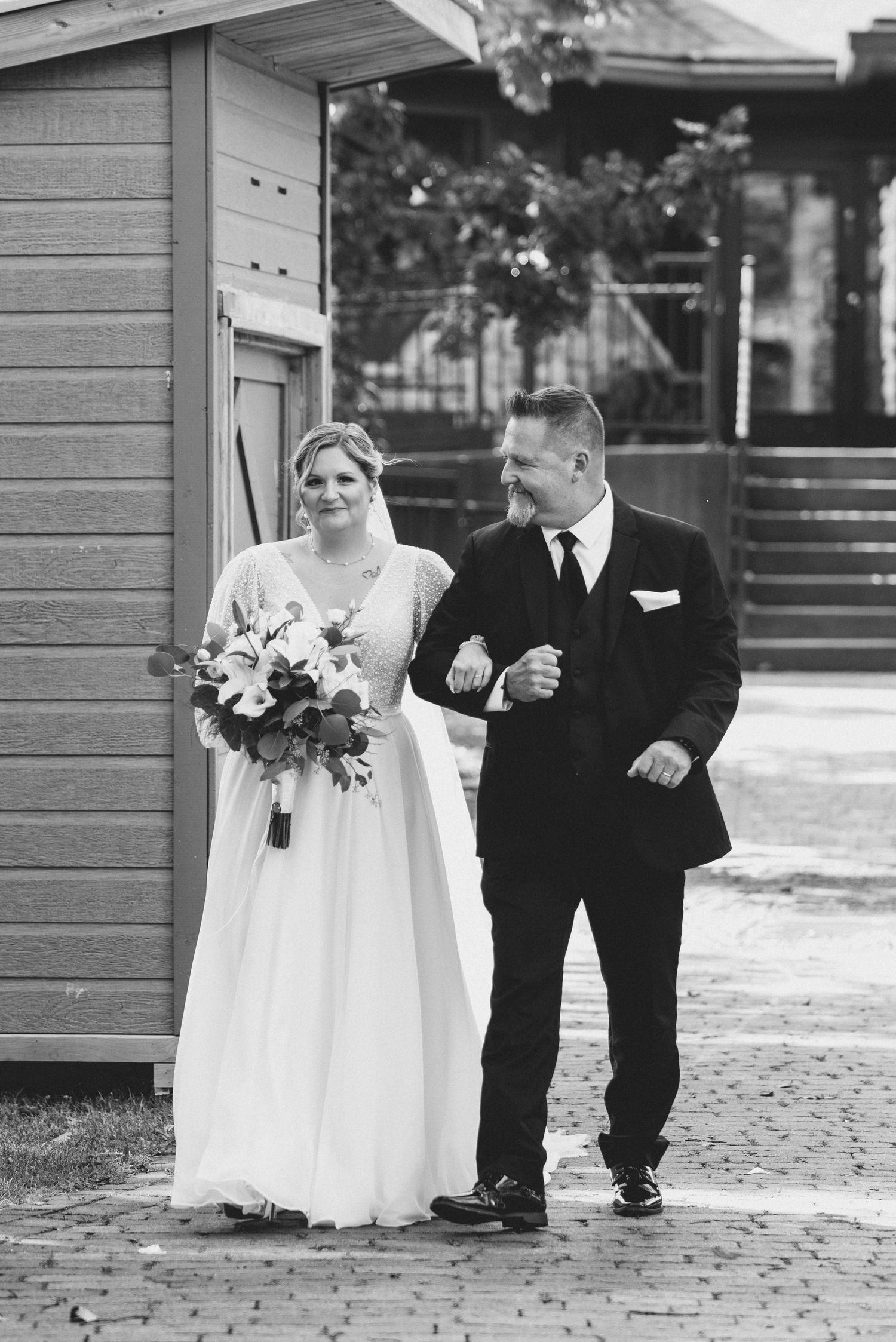 Black and white photo series showing a bride in white dress and groom in black suit walking together on a brick path.