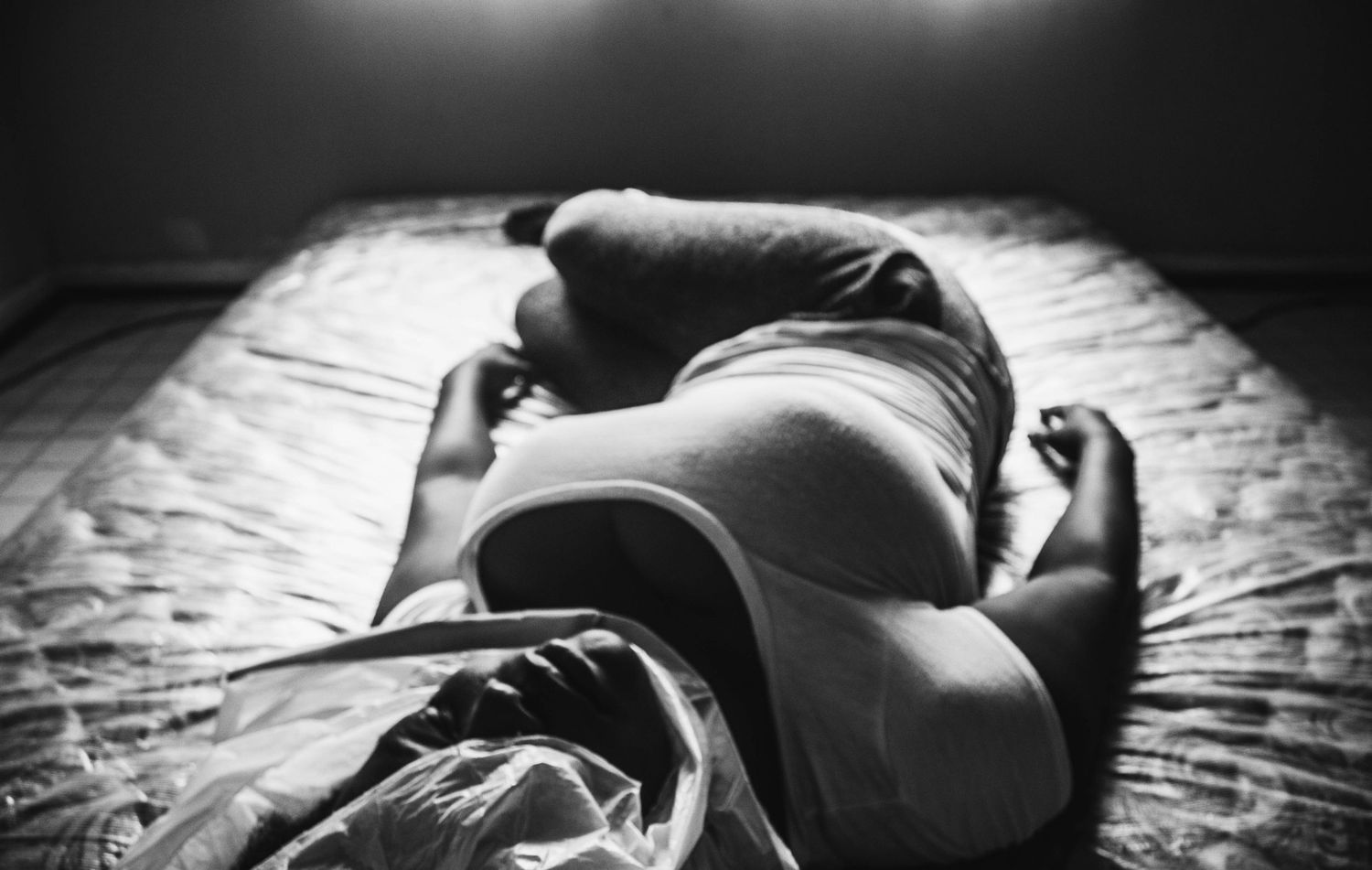 Black and white artistic photo series showing intimate moments of pregnancy and maternity in dramatic lighting.