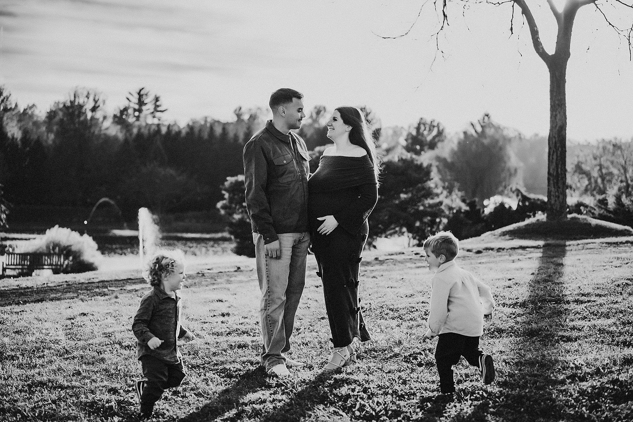 A black and white photo series of people playing and walking together in a park on a sunny winter day.