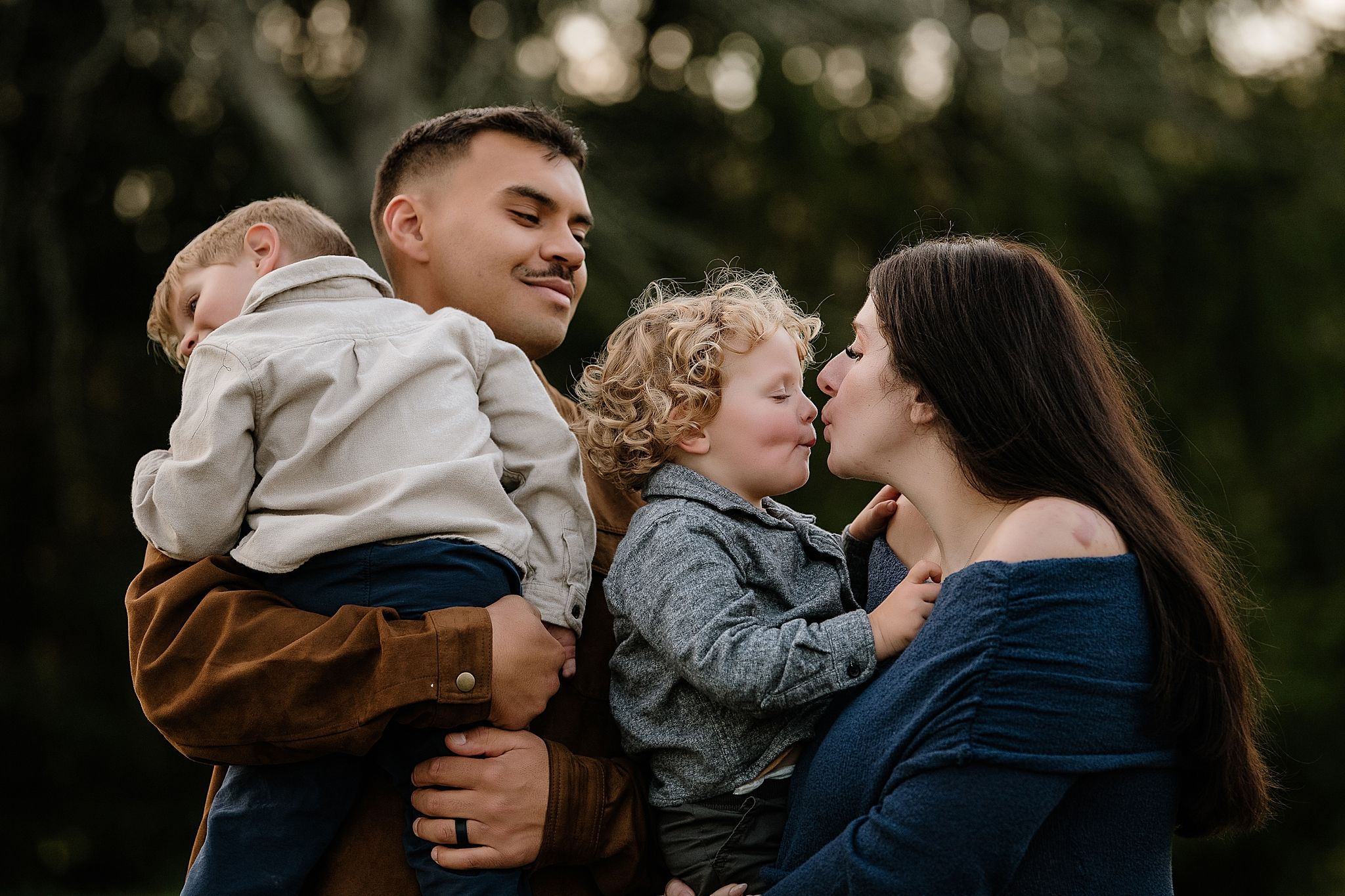 A romantic couple embraces in a tender moment outdoors during golden hour lighting.