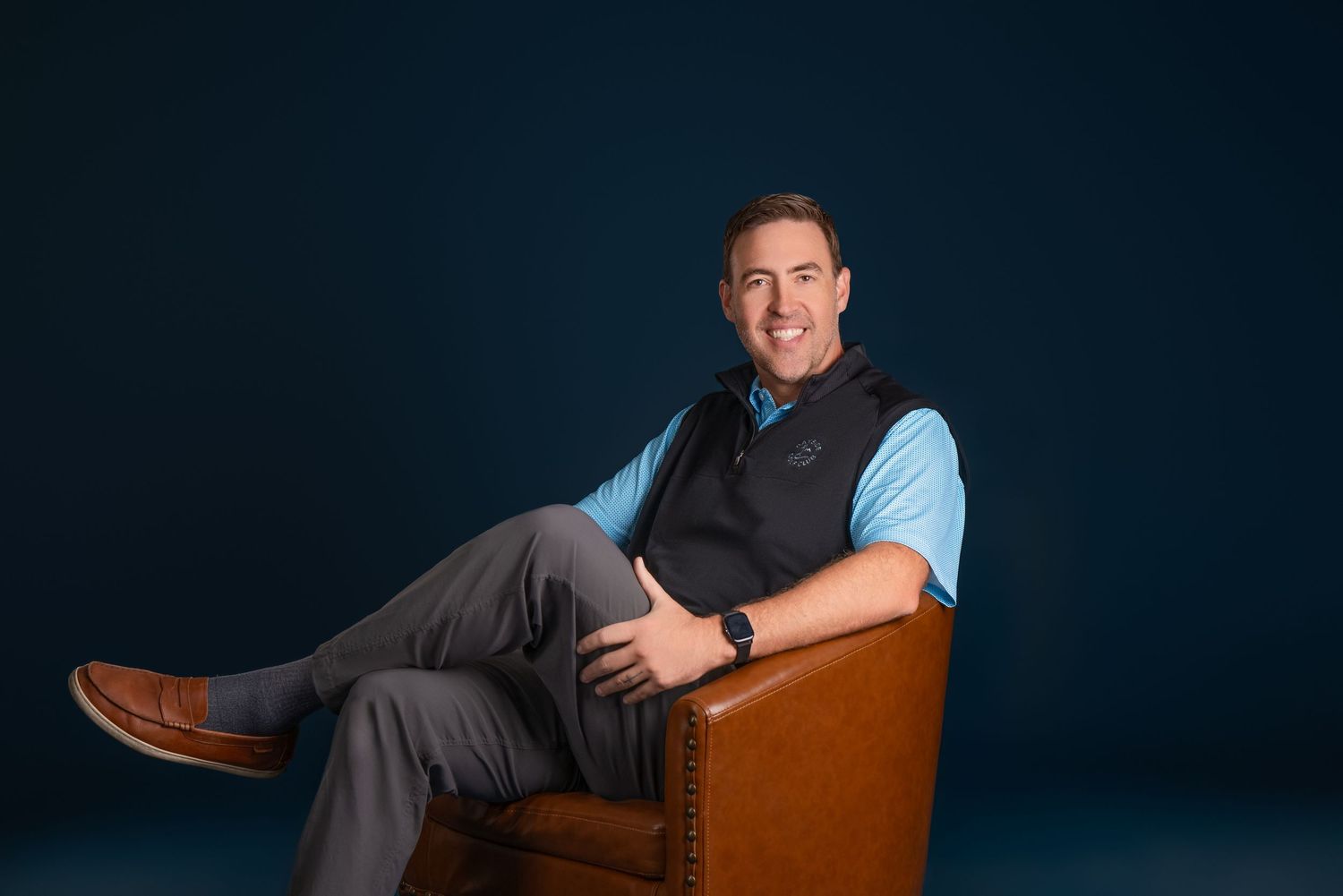 Professional headshot and business portraits of someone in a blue shirt against a dark background.