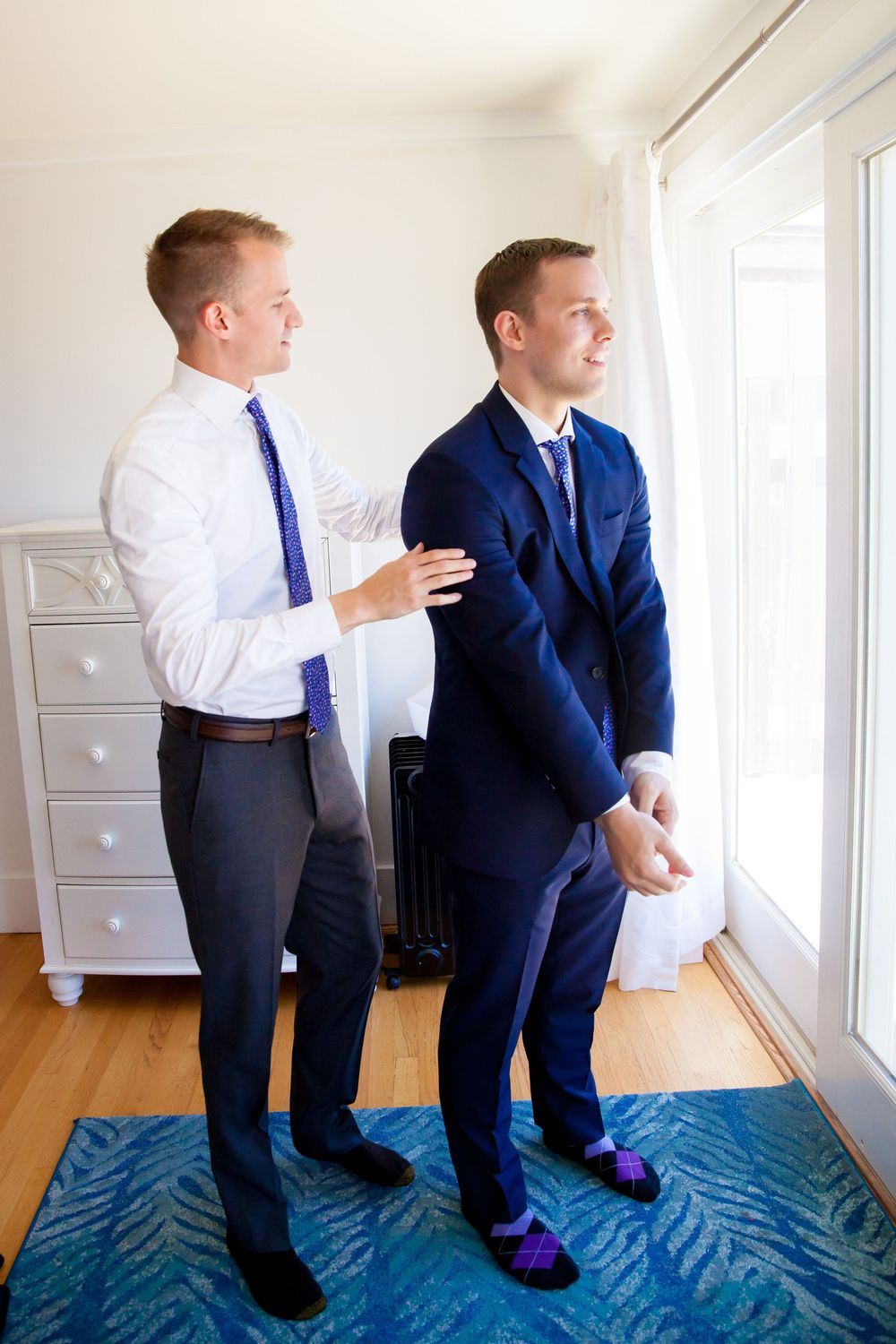 Two young boys in formal attire peek out a window in a series of playful poses.