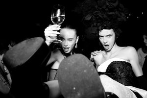 Black and white nightclub scene showing people dancing and socializing in a dimly lit space.