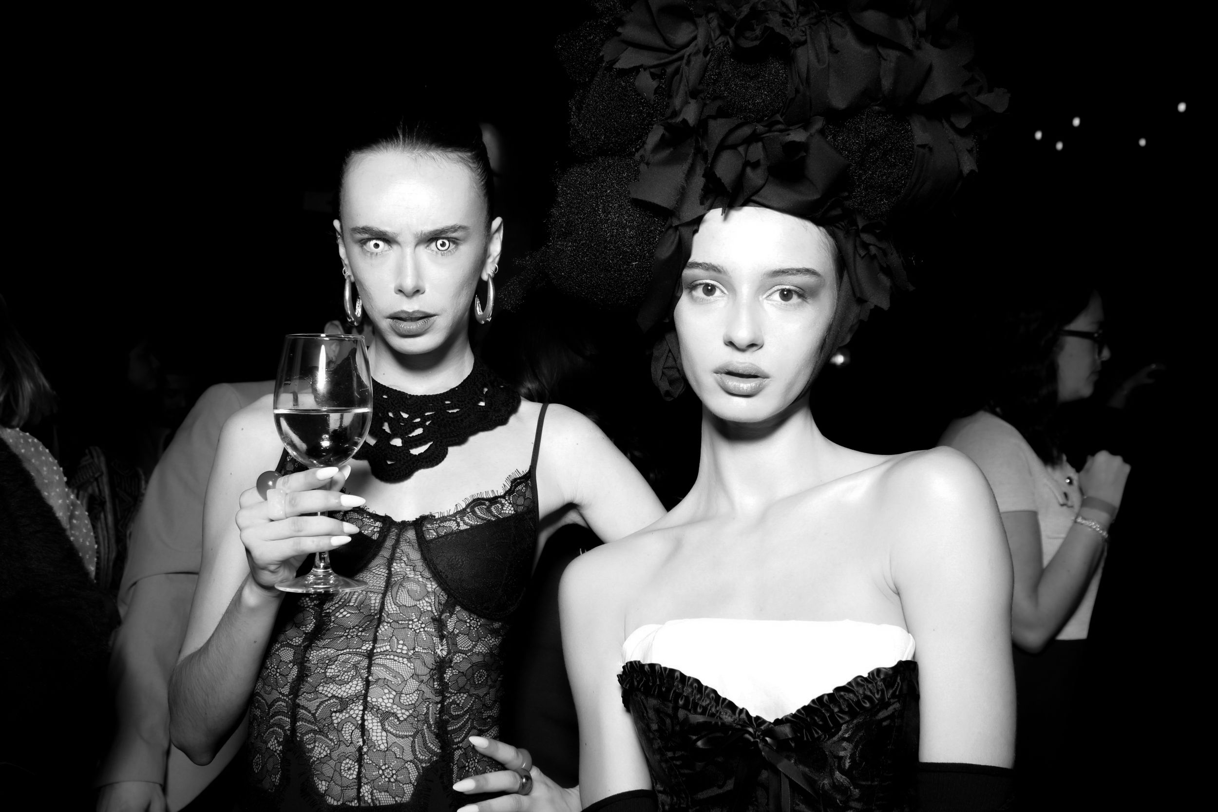 Black and white photos of people posing and performing in dramatic lighting at what appears to be a social event.