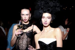 Models walk the runway in black lace and sheer evening wear during a fashion show presentation.