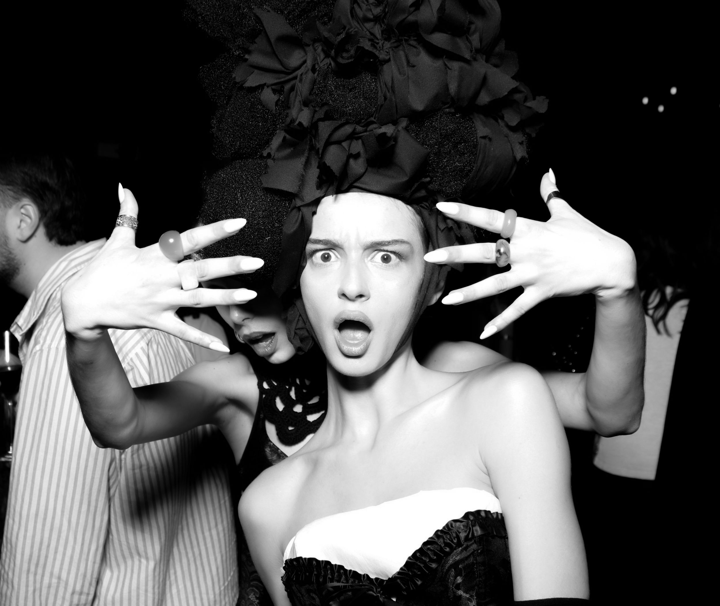 A sequence of black and white photos showing expressive hand gestures and dramatic poses in an artistic performance.