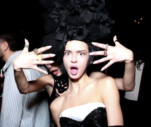 A sequence of four black and white photos showing someone making expressive hand gestures against a dark background.