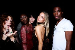 Group of friends dancing and enjoying themselves at a party in a dimly lit room.