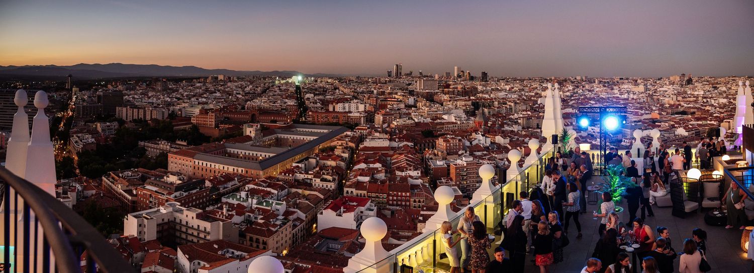 Panoramic cityscape view of Lisbon at sunset with orange and pink sky.