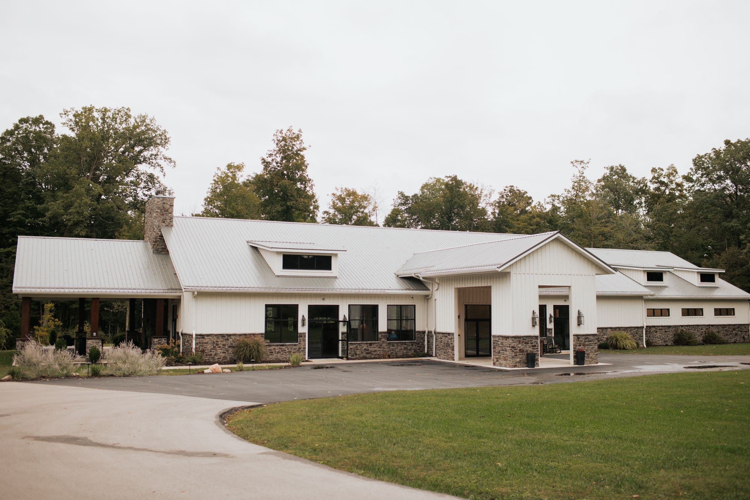 Exterior view of a long white church building with multiple entrances and landscaping.
