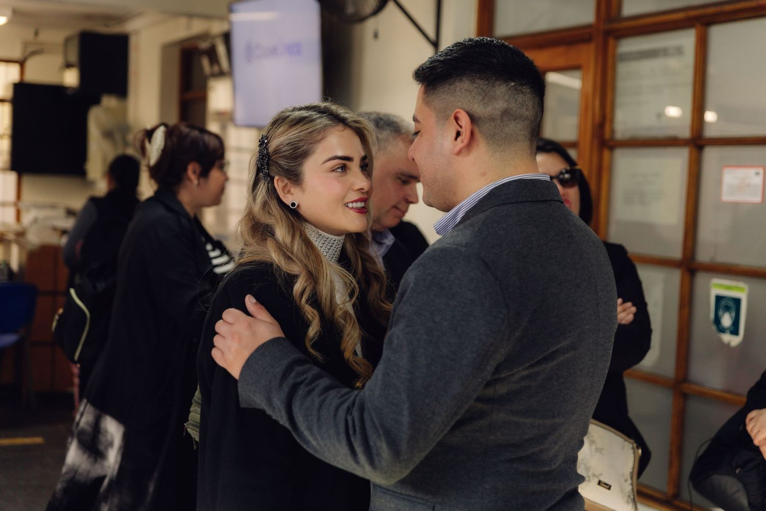 Young couple sharing an intimate moment at an indoor social gathering event.