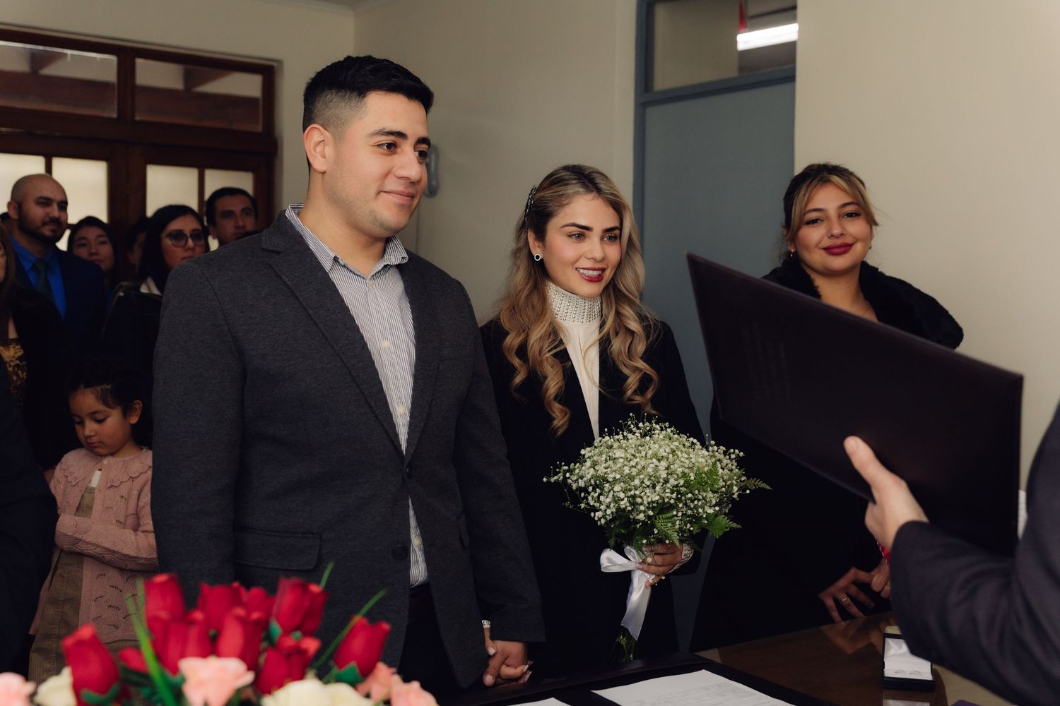 Happy couple receiving marriage certificate from officiant at civil wedding ceremony.