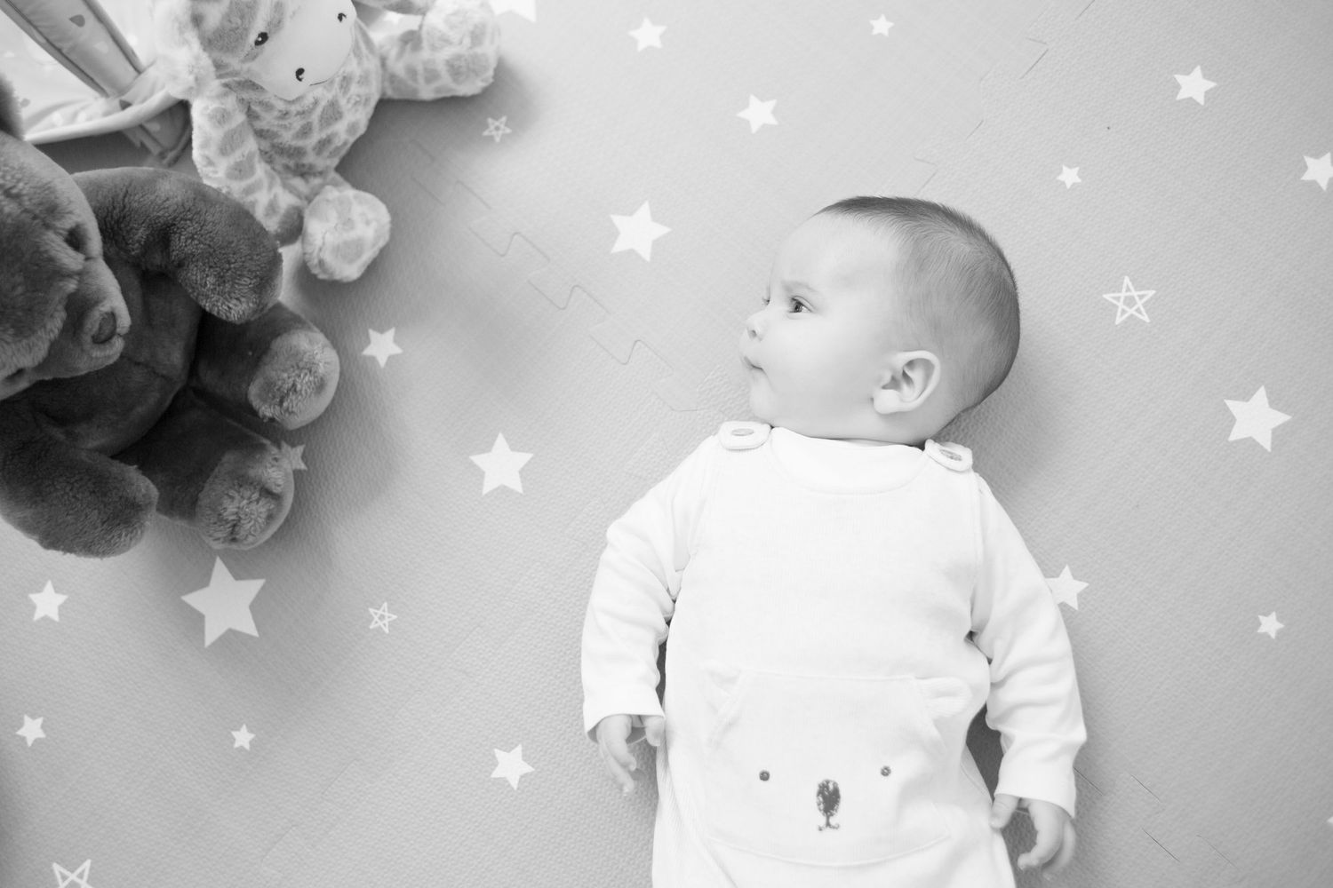 A black and white photo collage shows a baby's first year milestone photos with star decorations in the background.
