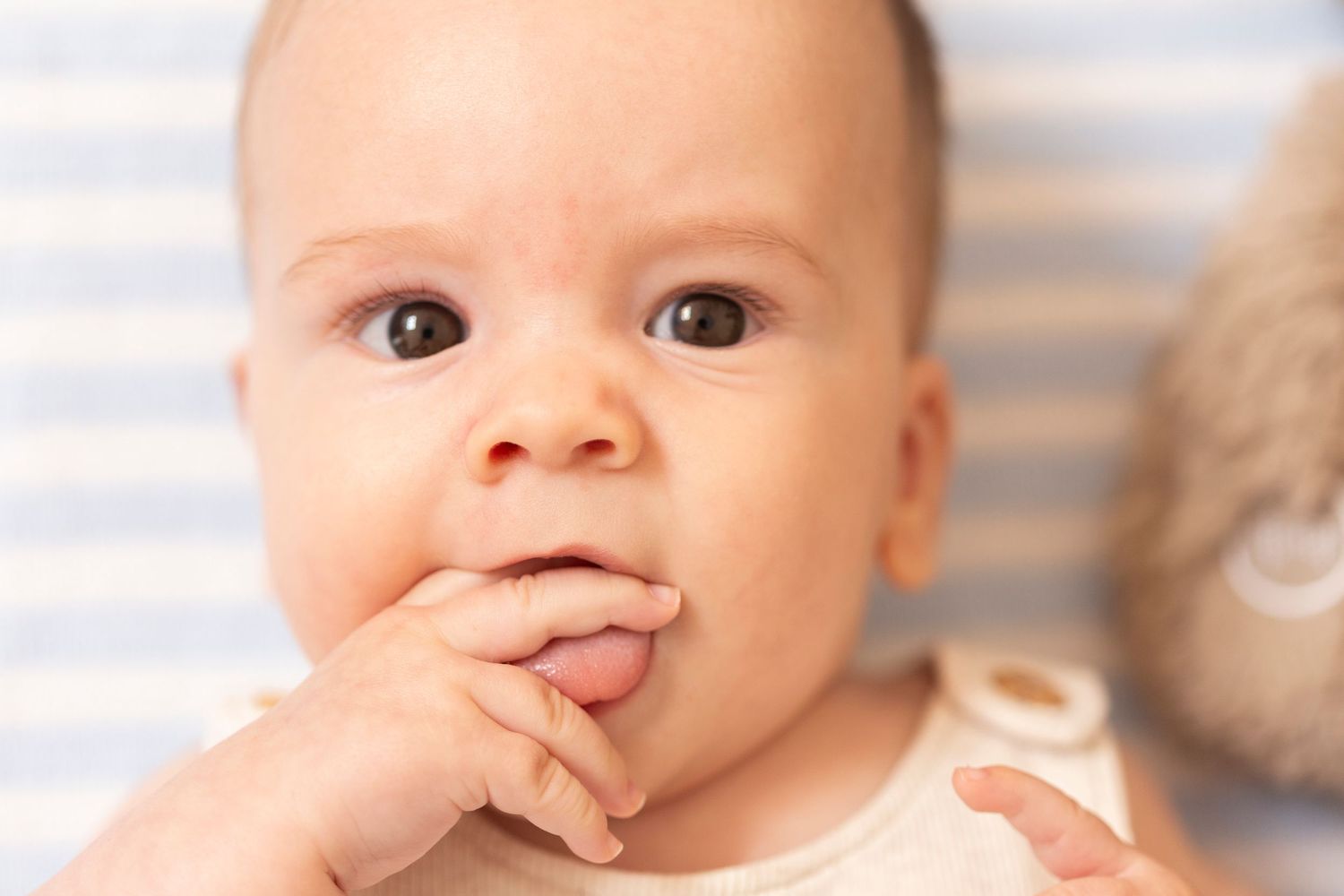 A baby making various playful facial expressions and gestures in a series of close-up photos.