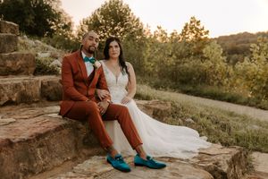 Couple sitting on stone steps during sunset wedding photoshoot.