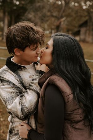 Romantic sequence of a couple kissing in a park during fall.