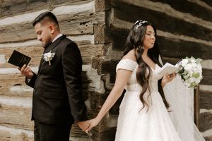 Romantic wedding couple embraces beneath rustic wooden beams in an intimate moment during their special day.