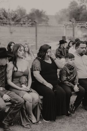 Wedding guests seated in rows outdoors watching the ceremony.
