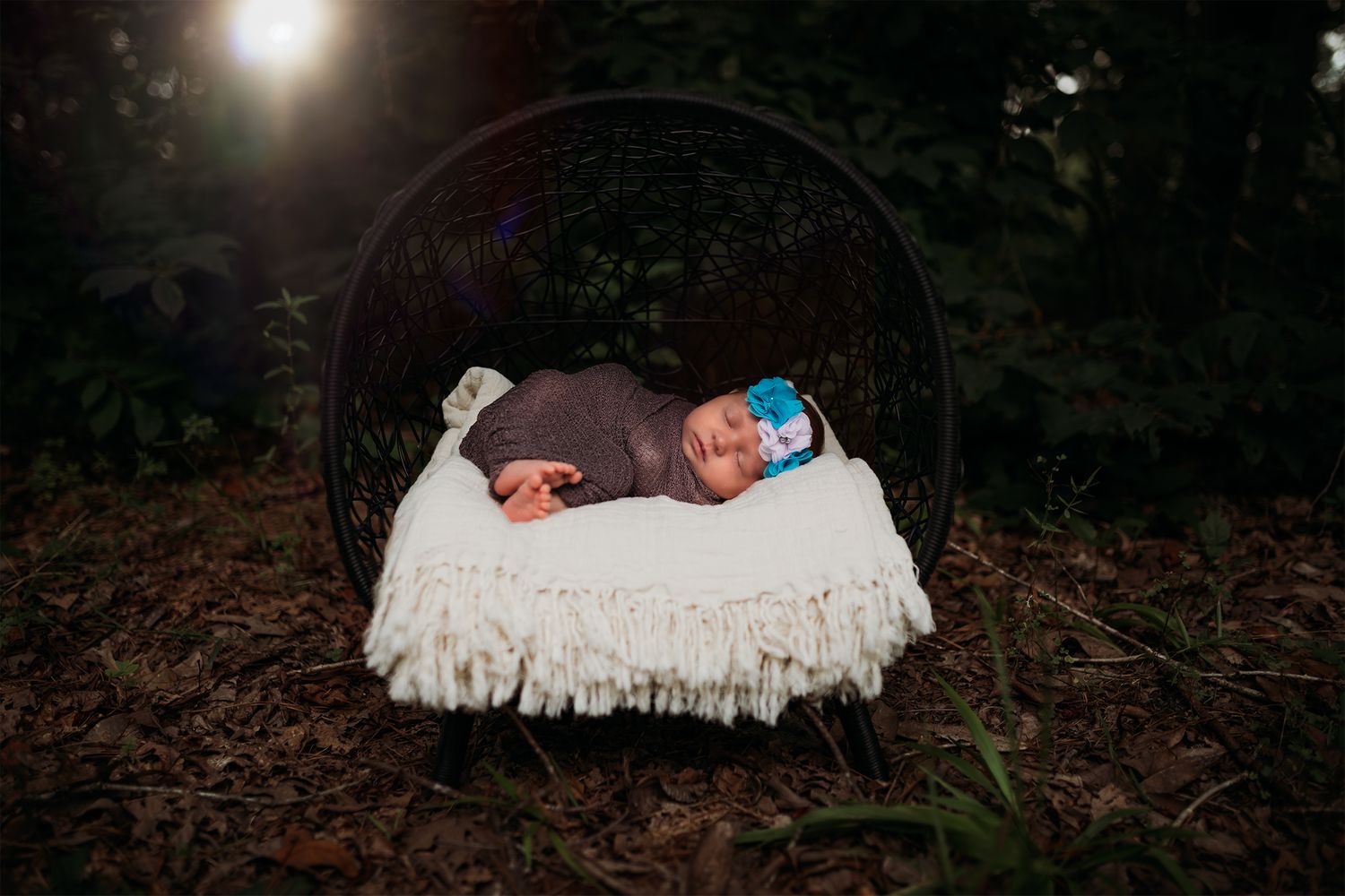 Nighttime outdoor photo session with dramatic lighting and a white blanket on the ground.