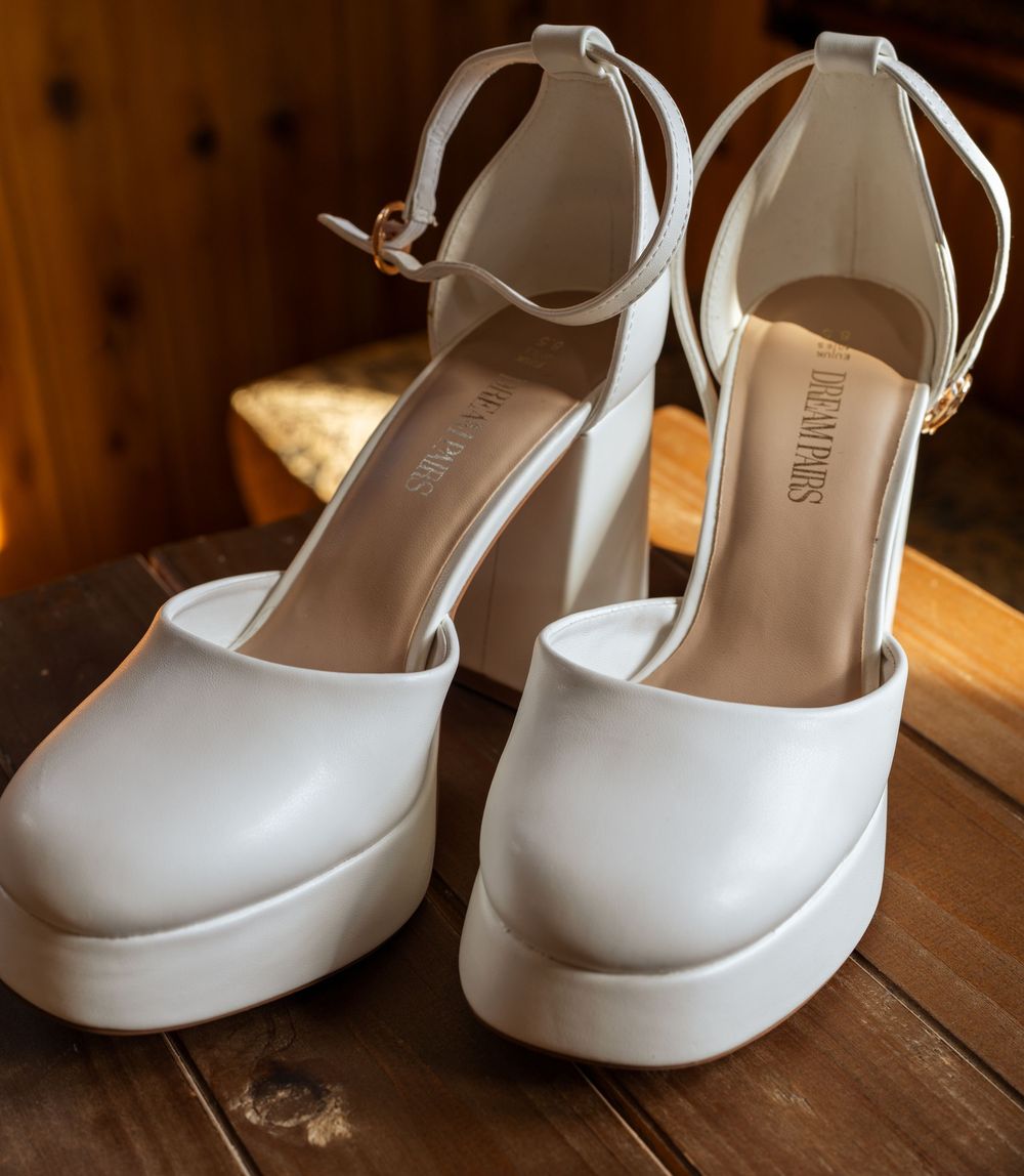 White bridal shoes displayed on a rustic wooden surface in varying angles.
