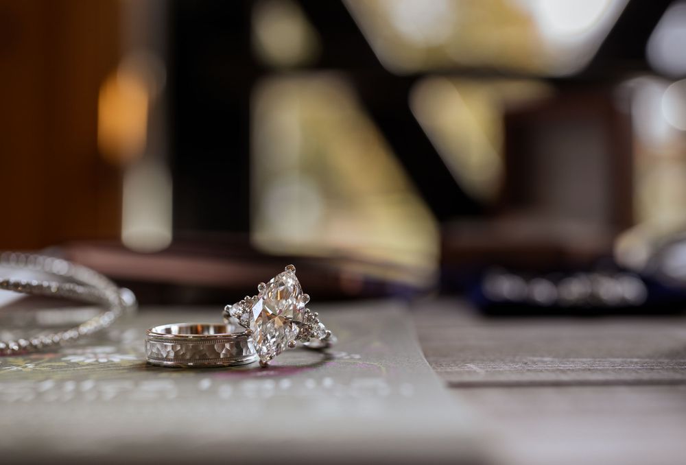 Elegant wedding rings displayed on wooden surface with soft focus background.