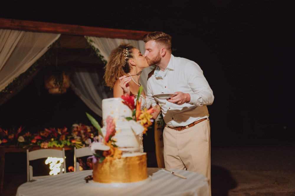 Wedding guests dance and celebrate during an evening reception under string lights.