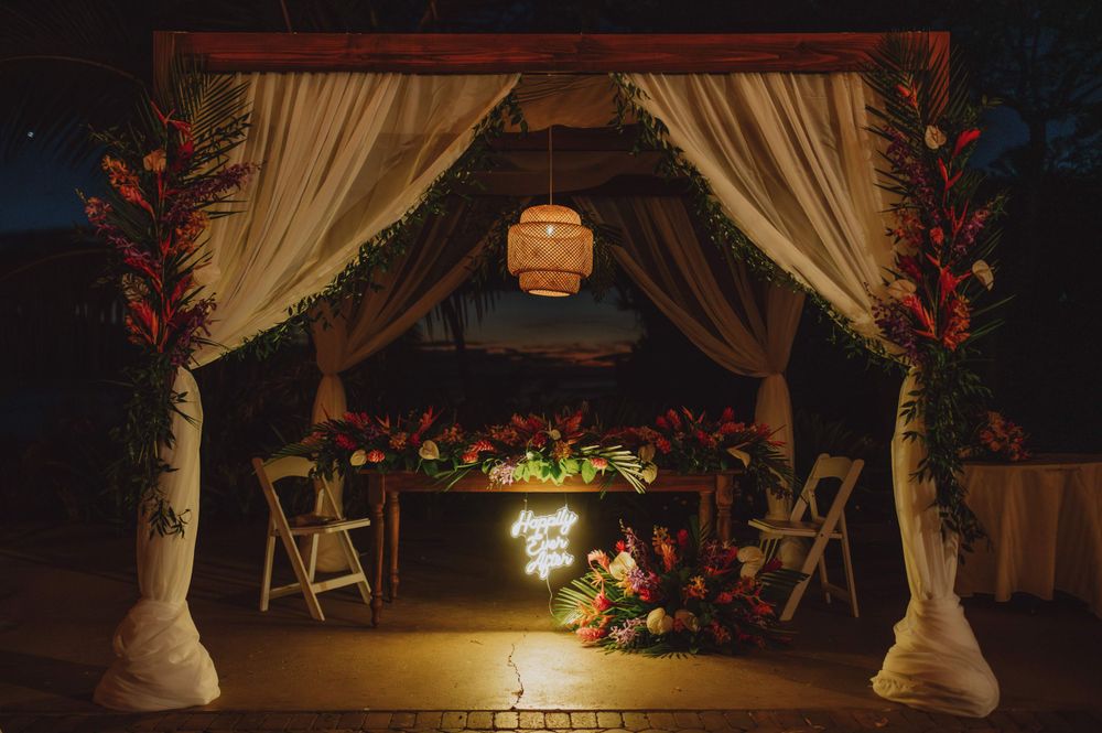 Evening wedding reception setup with draped fabric and hanging lights creating ambient atmosphere.