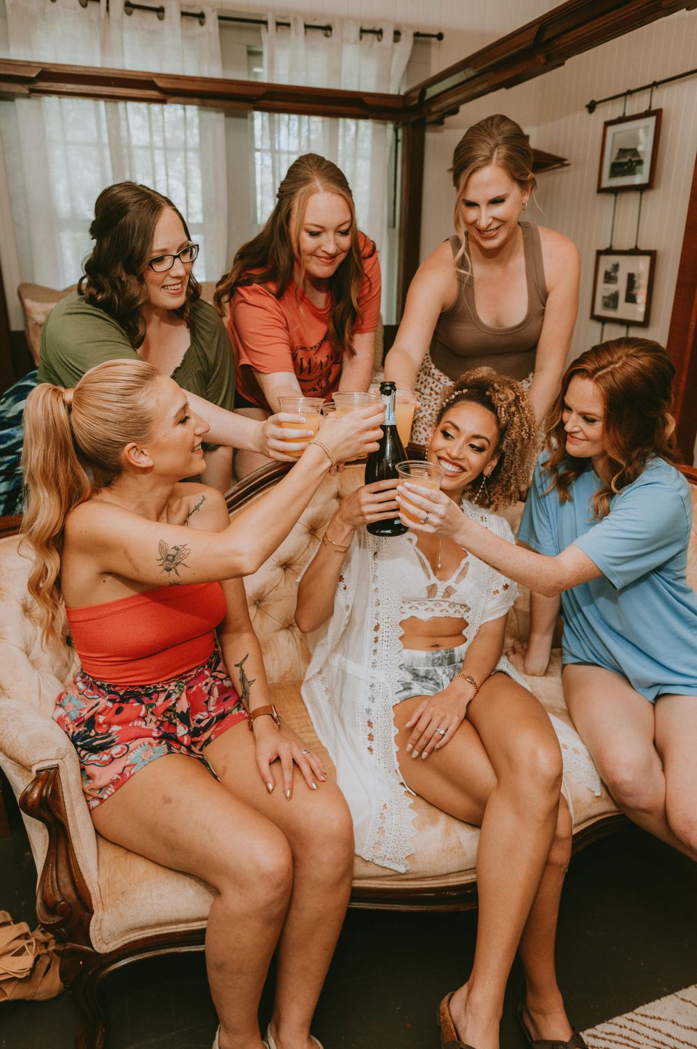 A group of friends laughing together while sitting on a couch during a casual gathering.