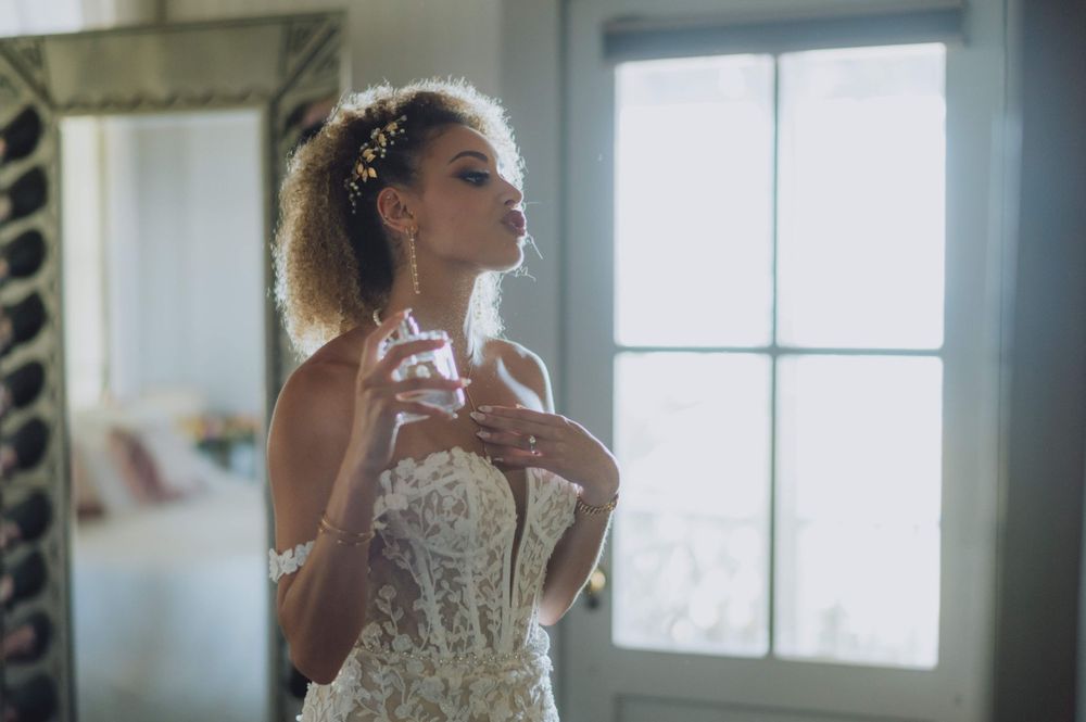 Sunlit bridal portraits near a window showing elegant wedding dress details.