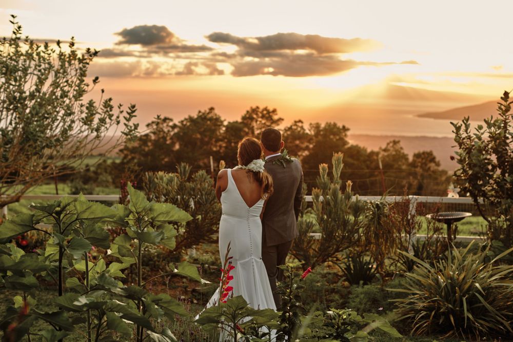 Sunset wedding ceremony setup with palm trees and ocean views in Hawaii.