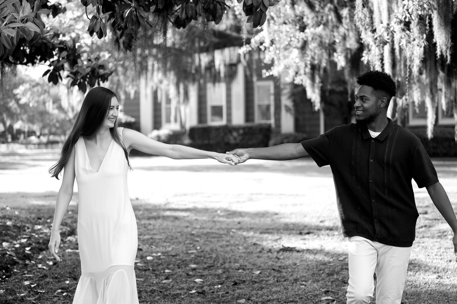 A series of black and white engagement photos showing a couple walking together outdoors.
