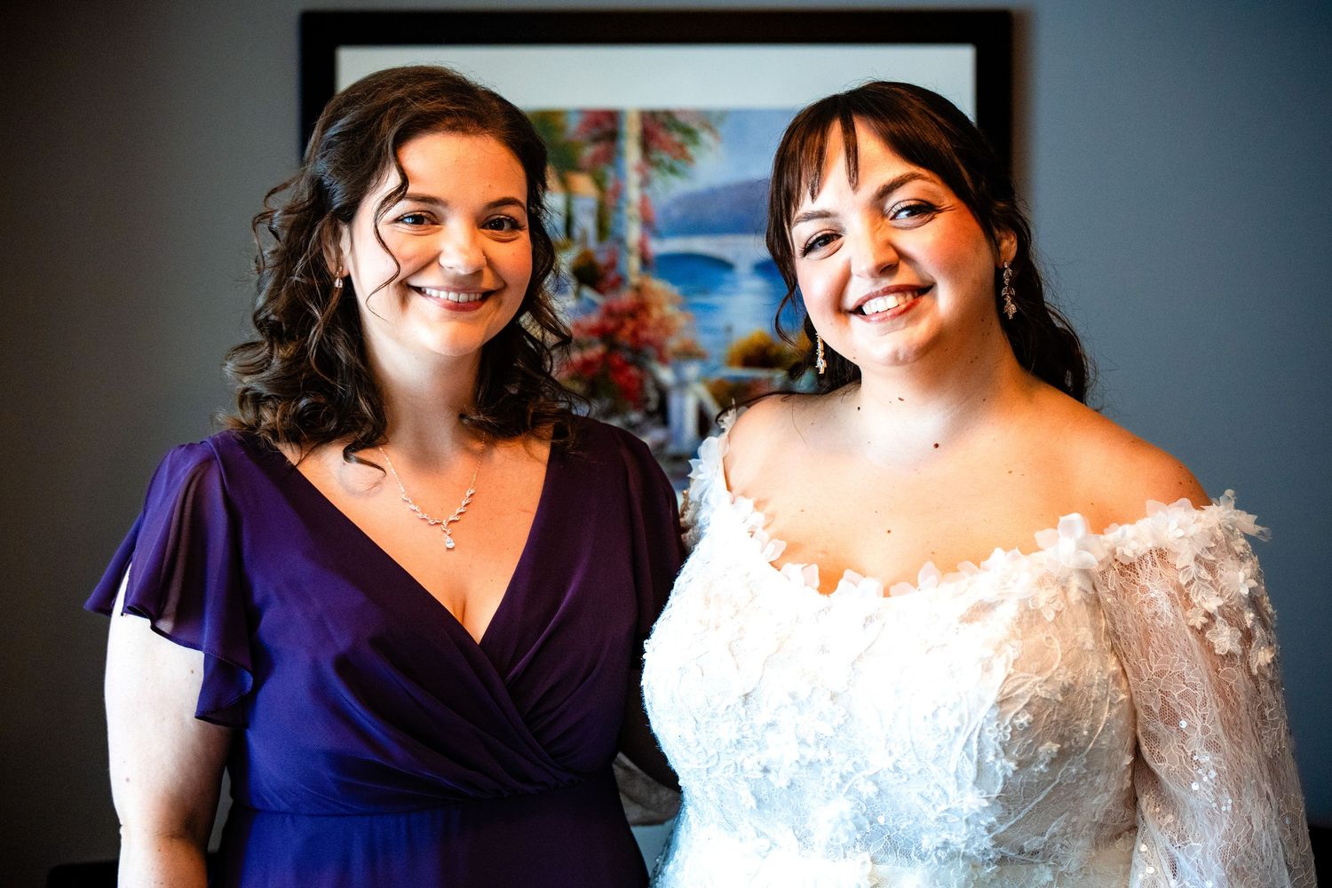 Bridesmaids in deep purple dresses pose with the bride in a white gown during a wedding celebration.