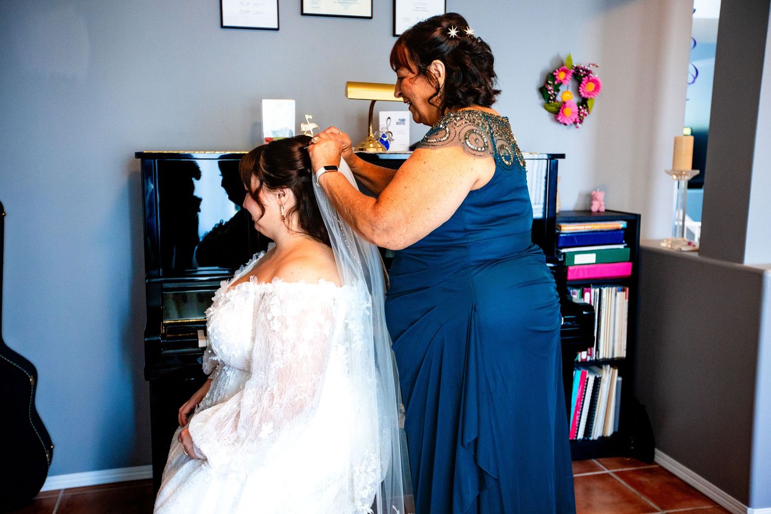 Bride and bridesmaids getting ready in a room with natural light streaming through windows.