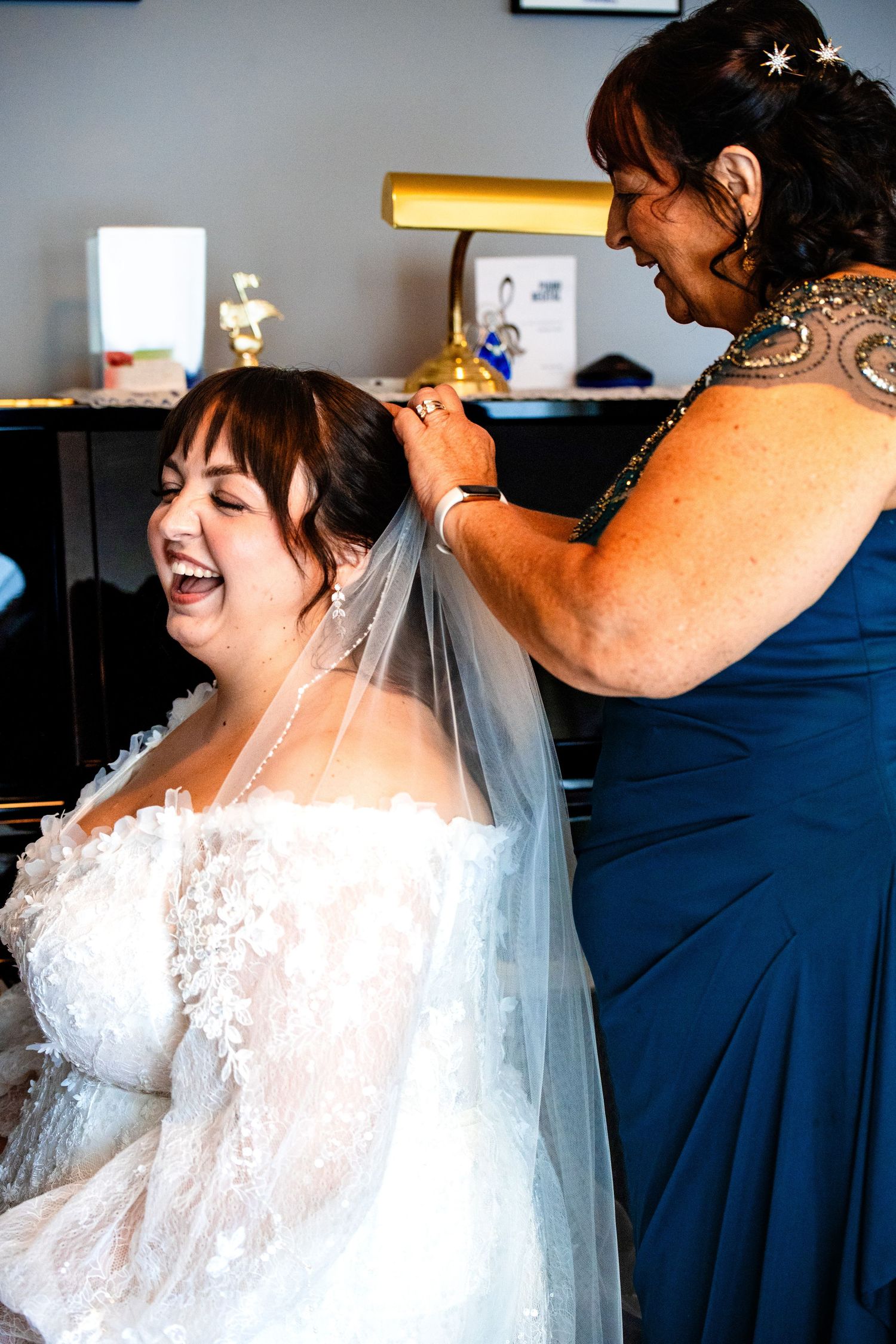 A series of intimate getting ready moments shows a bride in a lace wedding dress being helped with final preparations.