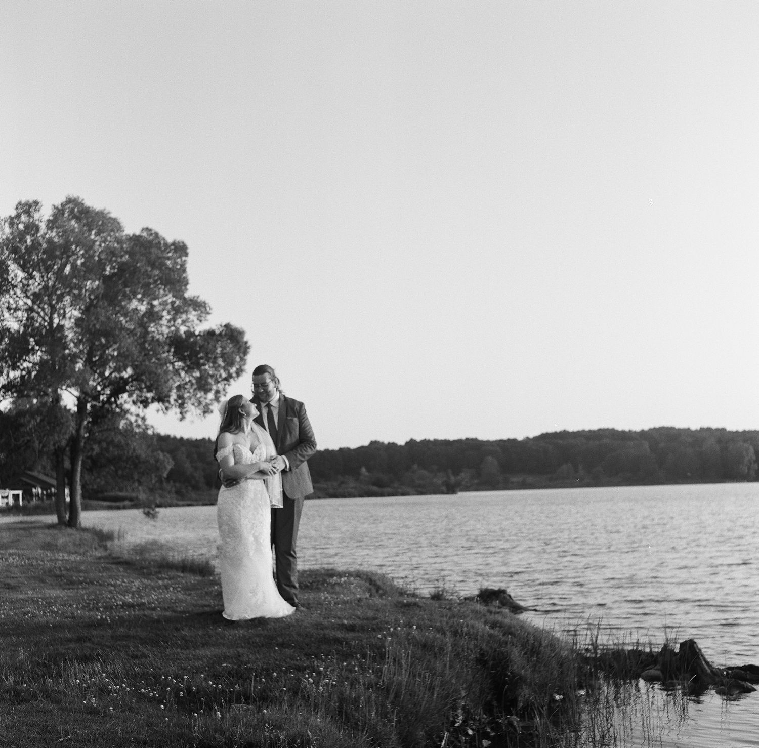 Romantic black and white lakeside photo series showing a couple enjoying peaceful moments by the water at sunset.