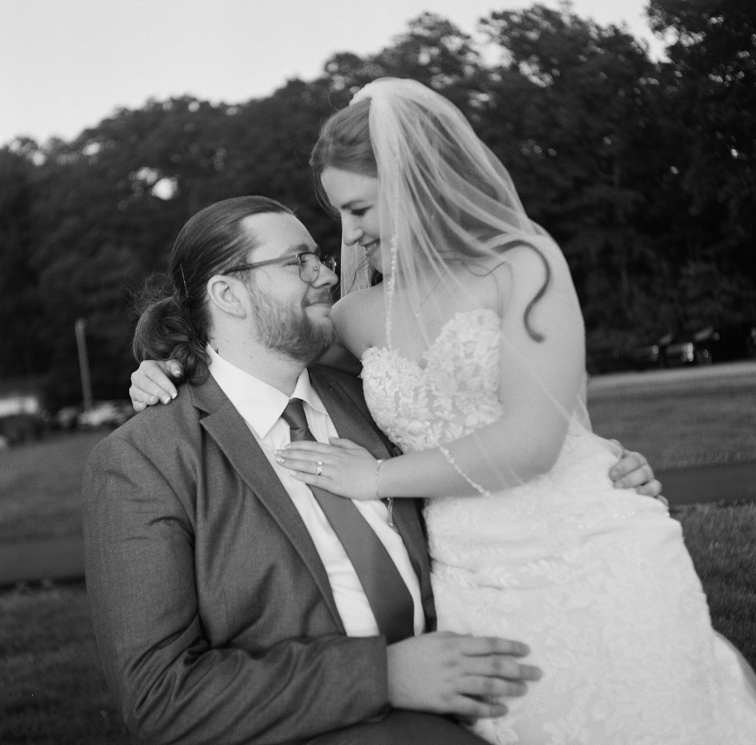 A romantic black and white photo sequence shows a couple in wedding attire sharing intimate kisses in an outdoor setting.