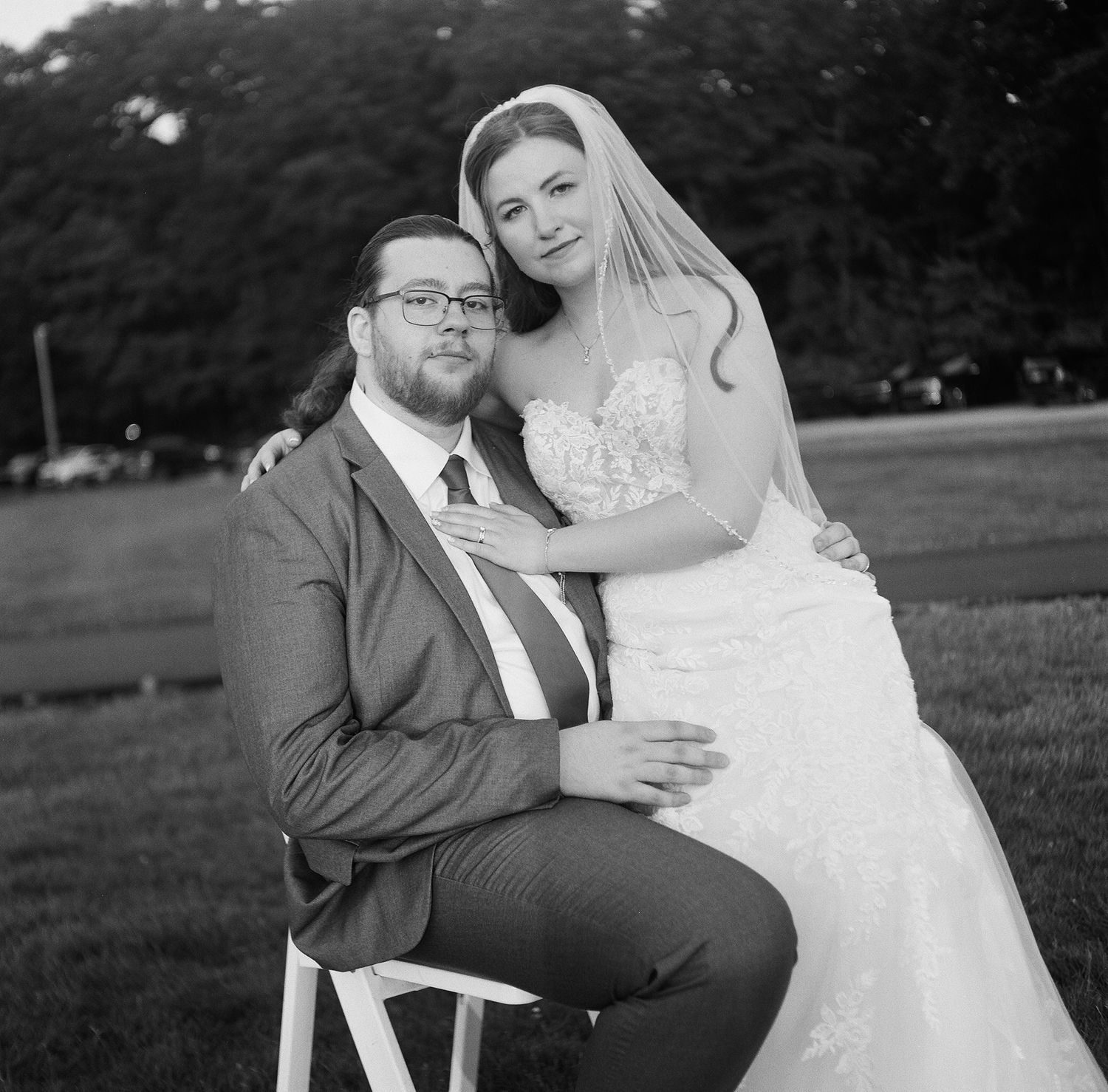 A romantic black and white wedding photo series showing tender moments between newlyweds in an outdoor setting.