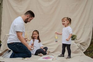 A series of candid family moments showing adults and children playing together against a beige backdrop.