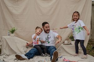 A sequence of candid family moments showing playtime and interactions on a beige backdrop.