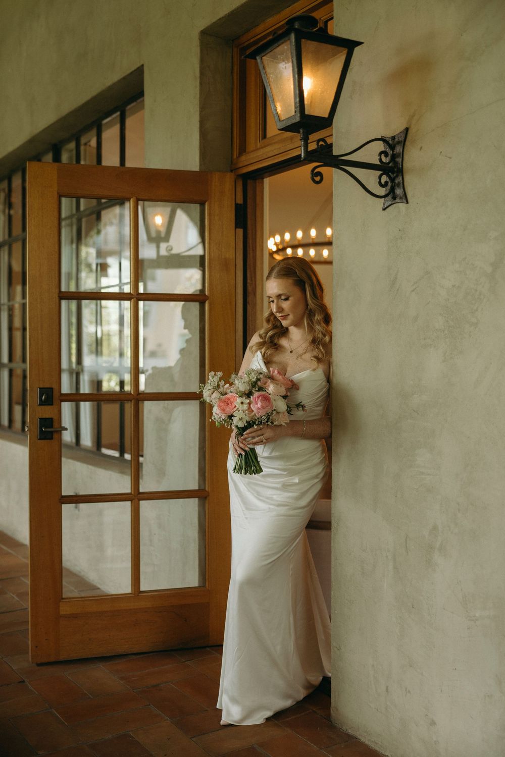 A romantic wedding sequence shows a couple in white embracing in a rustic hallway with warm lighting and wooden doors.