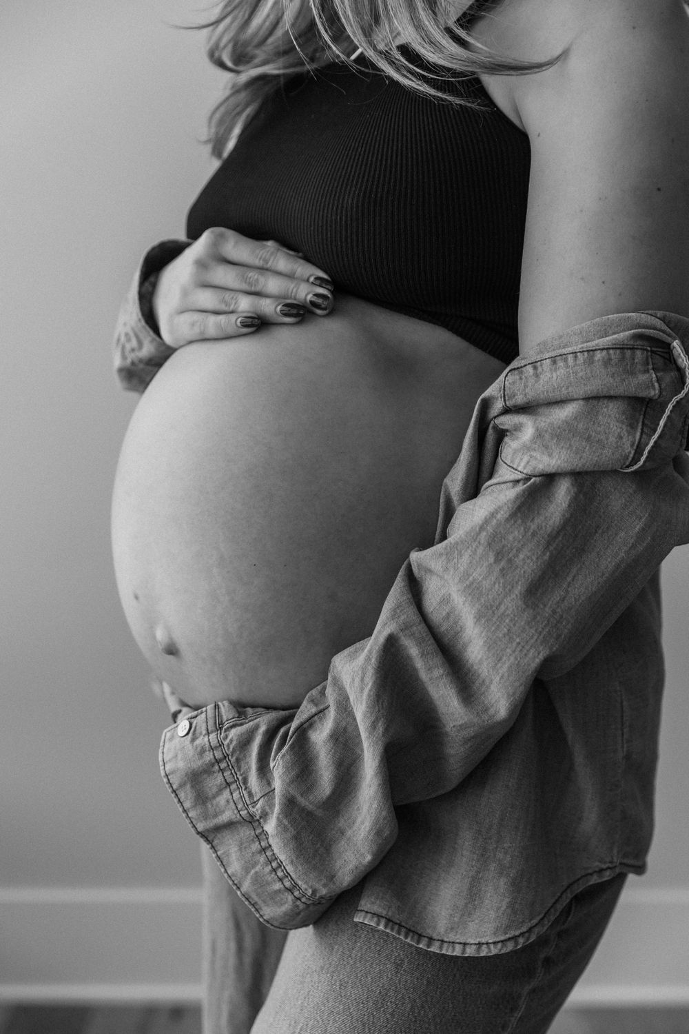 Black and white series of intimate maternity poses with denim jacket.