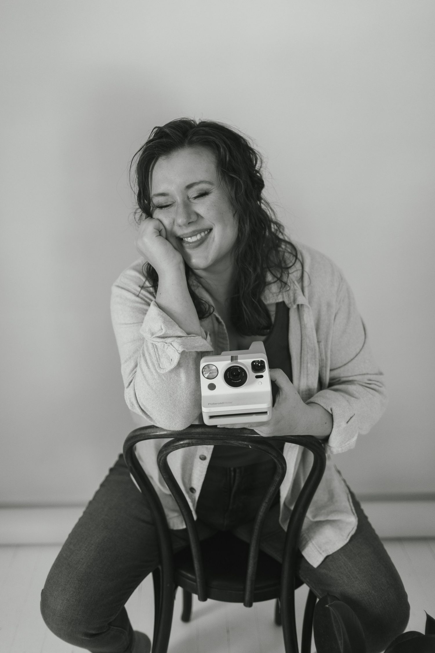 Black and white photo series showing someone in a white shirt taking photos with a vintage instant camera.