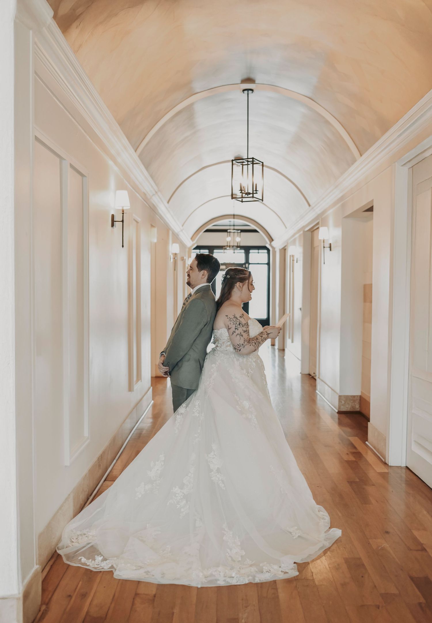 Bride and groom sharing a private first touch while exchanging handwritten love letters