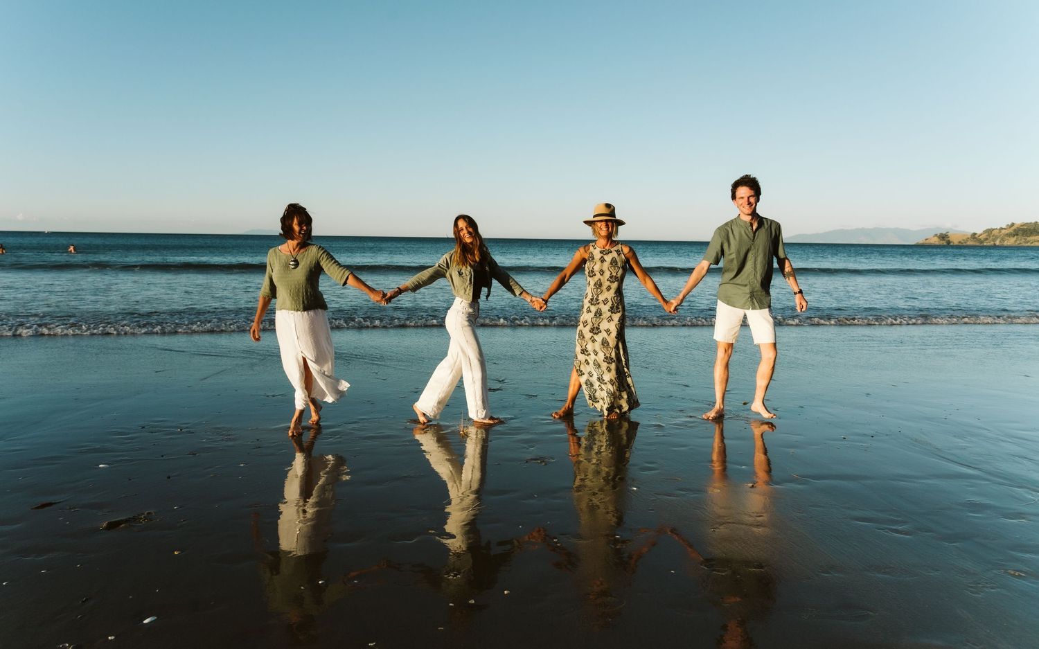 A collage of beach wedding photos showing newlyweds walking along sandy shores with turquoise ocean views.