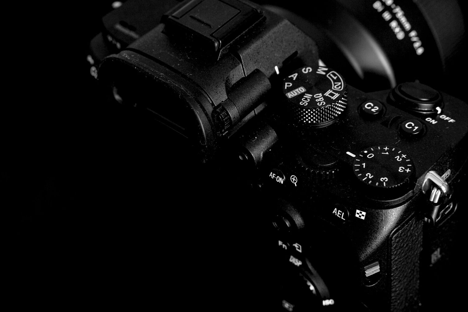 Close-up of camera dials and controls on black professional photography equipment.