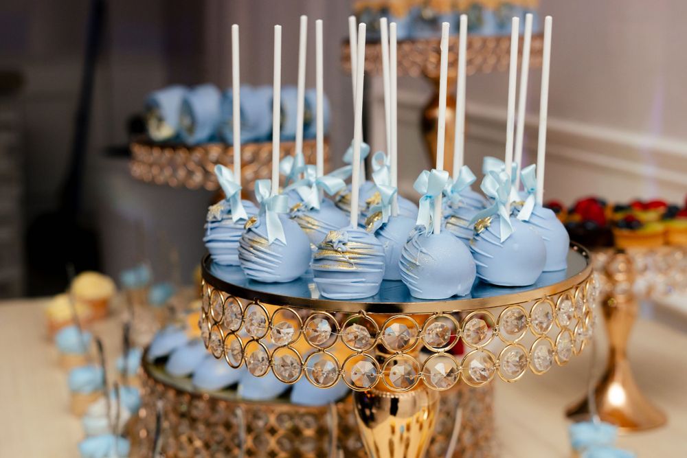 White cake pops and desserts displayed on elegant crystal stands at a wedding reception.
