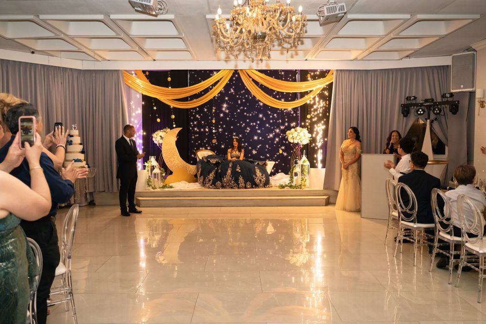Elegant ballroom with crystal chandeliers and draped fabric decorations for a formal event.