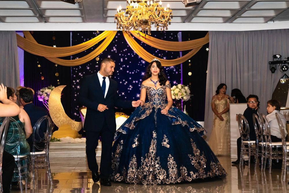 Ballroom celebration with elegant chandeliers and decorative fabric swags overhead.